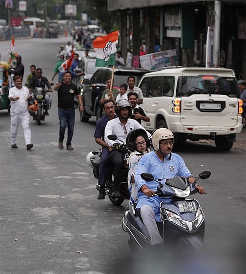 West Bengal Chief Minister and Trinamool Congress supremo Mamata Banerjee rides pillion on a scooter during a roadshow for the West Bengal Assembly elections, in Kolkata.
