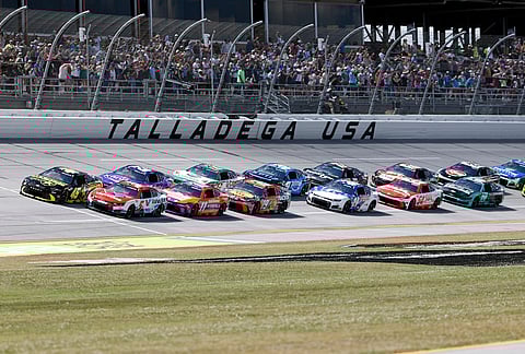 Tyler Reddick (45) and Kyle Larson (5) lead the pack to the start during a NASCAR Cup Series auto race, in Talladega, Alabama.