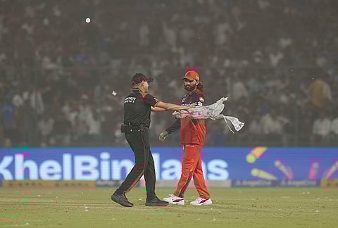 Royal Challengers Bengaluru's captain Rajat Patidar reacts amid a dust storm during the Indian Premier League (IPL) T20 cricket match between Delhi Capitals and Royal Challengers Bengaluru, in New Delhi.