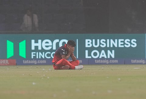A Royal Challengers Bengaluru's player reacts amid a dust storm during the Indian Premier League (IPL) T20 cricket match between Delhi Capitals and Royal Challengers Bengaluru, in New Delhi.