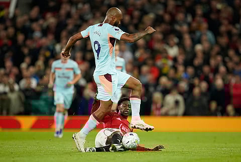 Manchester United's Kobbie Mainoo tackles Brentford's Igor Thiago during the Premier League soccer match between Manchester United and Brentford in Manchester, England.