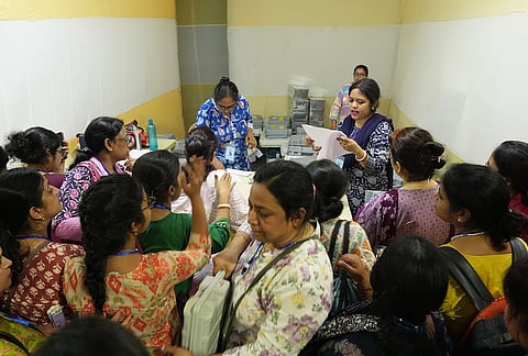 Polling officials check election materials for voting in the second phase of the West Bengal Assembly elections, at a distribution centre in Kolkata.