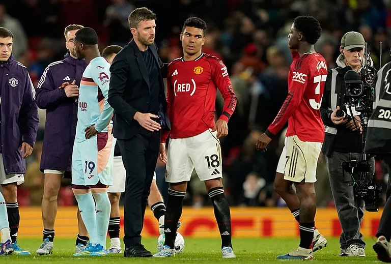 Manchester United's coach Michael Carrick talks to Casemiro, center, and Kobbie Mainoo after the Premier League soccer match between Manchester United and Brentford in Manchester, England. - | Photo: AP/Dave Thompson
