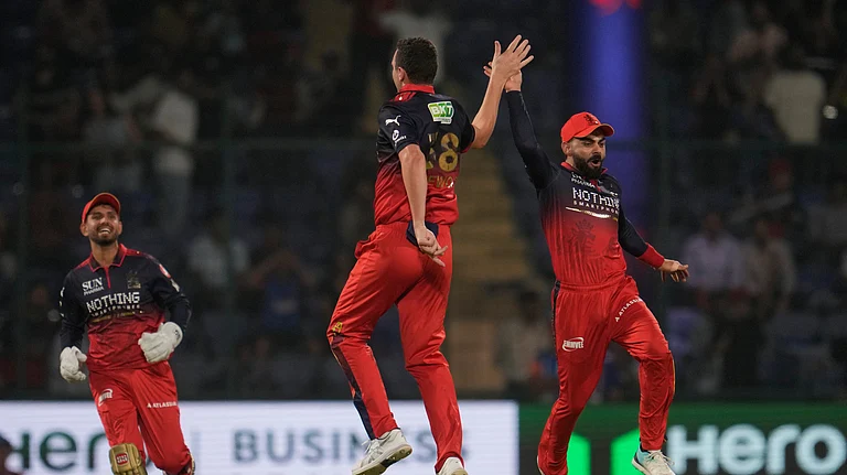 Royal Challengers Bengaluru's Josh Hazlewood, center, and Virat Kohli, right, celebrates the wicket of Delhi Capitals' Sameer Rizvi during the Indian Premier League cricket match between Delhi Capitals and Royal Challengers Bengaluru in Delhi, India, Monday, April 27, 2026. - (AP Photo/Manish Swarup)