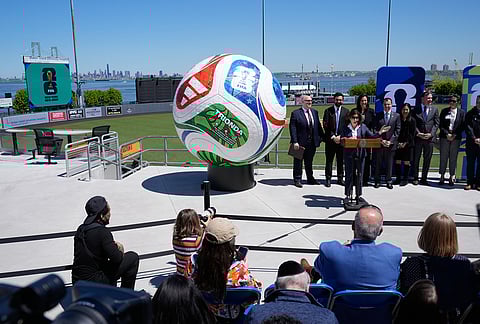 New York Governor Kathy Hochul, third from left, speaks in front of a large soccer ball and the city skyline during a news conference in the Staten Island borough of New York.