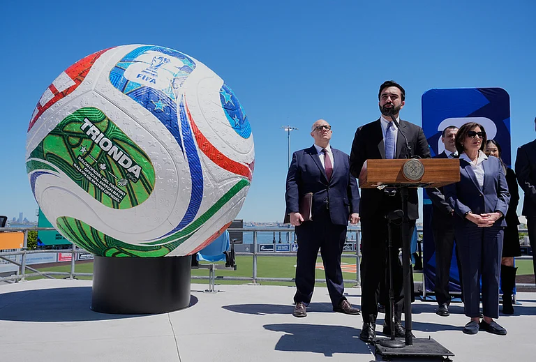 New York City Mayor Zohran Mamdani, second from left, speaks next to a large soccer ball during a news conference in the Staten Island borough of New York. - | Photo: AP/Seth Wenig