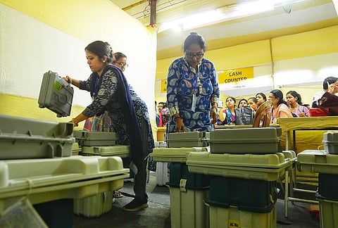 Polling officials collect Electronic Voting Machine (EVM) and Voter Verifiable Paper Audit Trail (VVPAT) units at a distribution centre on the eve of second phase of voting in the West Bengal Assembly elections, in Kolkata.