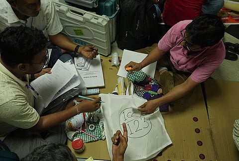 Polling officials check election materials for voting in the second phase of the West Bengal Assembly elections, at a distribution centre in Kolkata.