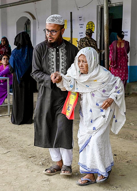 An elderly woman being assisted at a polling station during voting in the second and final phase of the West Bengal Assembly elections, in Nadia.