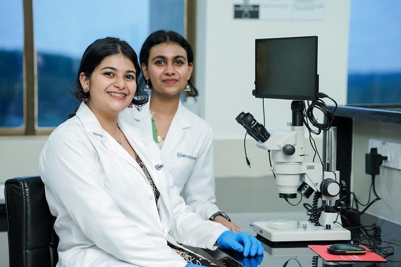 Two female scientists with a lab microscope