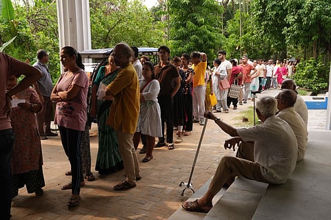 People wait in queues before casting votes in the second and final phase of the West Bengal Assembly elections, at a polling station in Kolkata. 