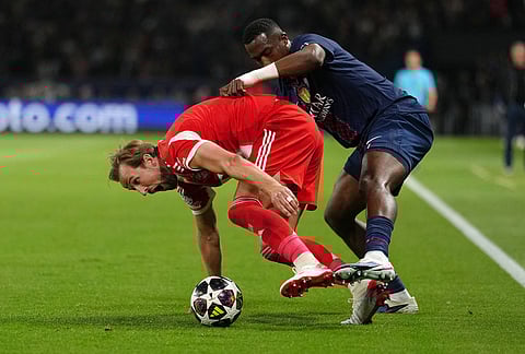 PSG's Willian Pacho fights for the ball with Bayern's Harry Kane, left, during a Champions League semifinal, first leg, soccer match between Paris Saint-Germain and Bayern Munich in Paris.