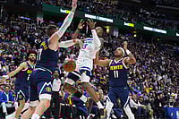 | Photo: AP/David Zalubowski : Minnesota Timberwolves guard Ayo Dosunmu, center, loses control of the ball while driving to the net between Denver Nuggets center Jonas Valanciunas, left, and guard Bruce Brown in the second half in Game 5 of a first-round NBA playoffs basketball series in Denver.