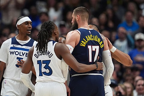 Minnesota Timberwolves forward Jaden McDaniels, left, exchanges words with Denver Nuggets center Jonas Valanciunas, center right, as Minnesota guards Ayo Dosunmu, front left, and Jaylen Clark surround Valanciunas in the second half in Game 5 of a first-round NBA playoffs basketball series in Denver.