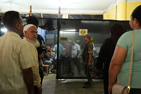 People wait in queues before casting votes in the second and final phase of the West Bengal Assembly elections, at a polling station in Kolkata.
