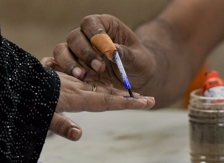 Kolkata: A polling official marks a voter's finger with indelible ink during the second and final phase of the West Bengal Assembly elections, at a polling station in Kolkata - PTI