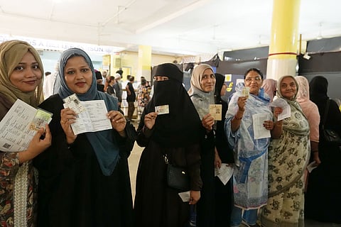 Women show their IDs as they wait in a queue before casting votes in the second and final phase of the West Bengal Assembly elections, at a polling station in Kolkata.