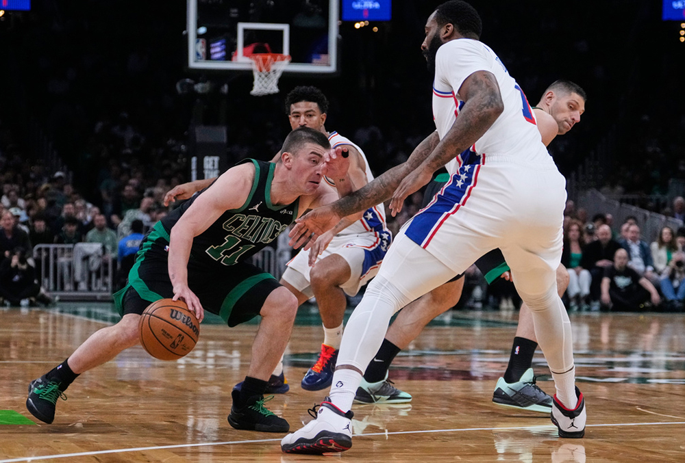 Boston Celtics guard Payton Pritchard (11) tries to drive through the Philadelphia 76ers during the first half of Game 5 of a first-round NBA playoffs basketball series, in Boston.