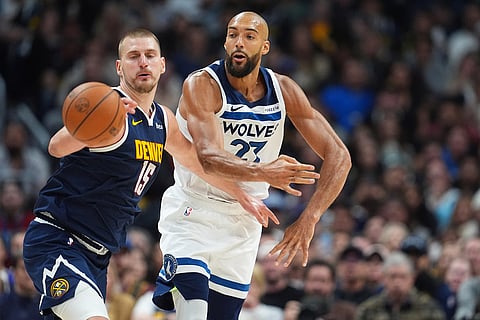 Denver Nuggets center Nikola Jokic, left, fights for control of the ball with Minnesota Timberwolves center Rudy Gobert in the second half in Game 5 of a first-round NBA playoffs basketball series in Denver.