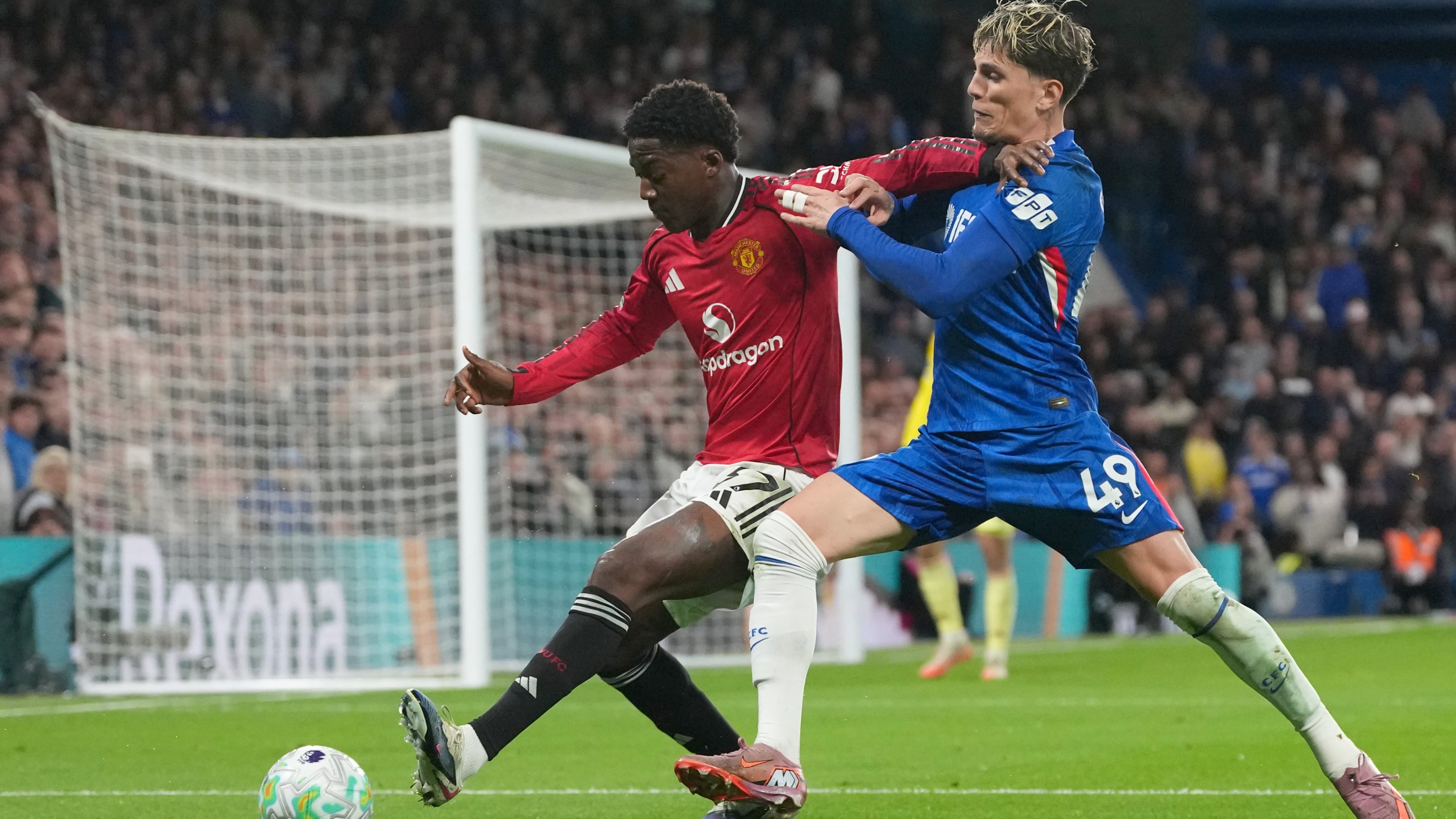 Manchester United's Kobbie Mainoo, left, and Chelsea's Alejandro Garnacho challenge for the ball during the English Premier League soccer match between Chelsea and Manchester United in London, Saturday, April 18, 2026. - | Photo: AP/Kirsty Wigglesworth