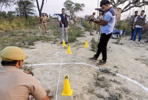 | Photo: PTI : Police and other other officials present at the site as they investigate the triple murder case, in Bulandshahr, Uttar Pradesh.