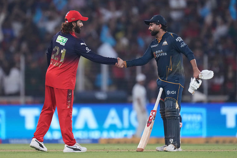 Gujarat Titans' Rahul Tewatia shakes hands with Royal Challengers Bengaluru's captain Rajat Patidar after wining the Indian Premier League cricket match between Gujarat Titans and Royal Challengers Bengaluru in Ahmedabad, India. - | Photo: AP/Ajit Solanki