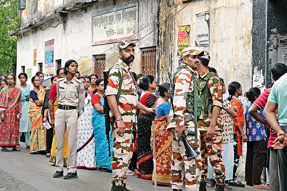 Guns and Forces: Voters line up to cast their vote in the second phase of the West Bengal election amid heavy security - | Photo: Sandipan Chatterjee
