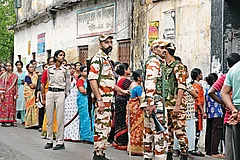 | Photo: Sandipan Chatterjee : Guns and Forces: Voters line up to cast their vote in the second phase of the West Bengal election amid heavy security