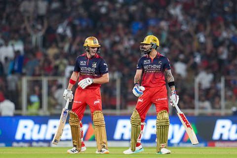 Royal Challengers Bengaluru's Virat Kohli and Jacob Bethell interact during the Indian Premier League (IPL) 2026 T20 cricket match between Gujarat Titans and Royal Challengers Bengaluru, in Ahmedabad, Gujarat.