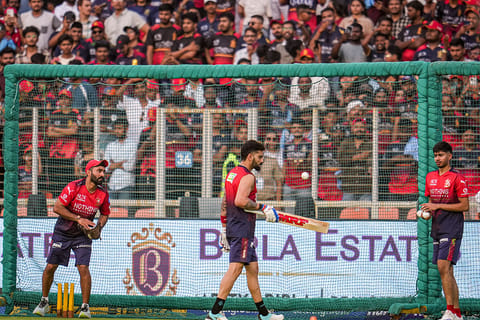 Royal Challengers Bengaluru’s Virat Kohli, centre, with team's Mentor and Batting Coach Dinesh Karthik, left, during a warm-up session before an Indian Premier League (IPL) 2026 T20 cricket match between Gujarat Titans and Royal Challengers Bengaluru, in Ahmedabad, Gujarat.