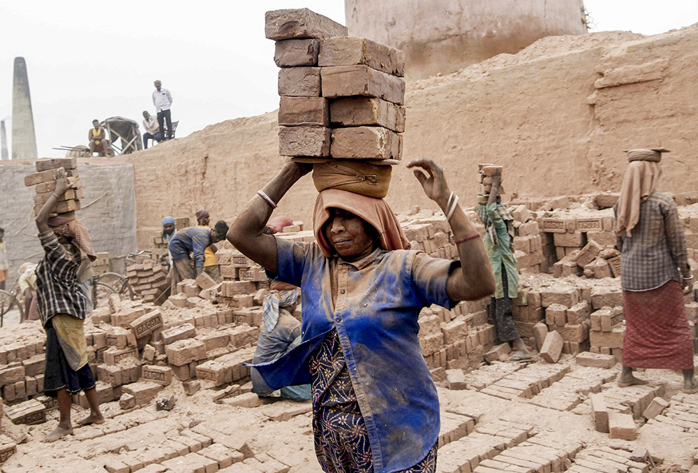 Labourers carry bricks at a brick factory, on the eve of Labour Day, also known as May Day, in Patna, Bihar.