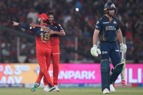 Royal Challengers Bengaluru's Bhuvneshwar Kumar celebrates the wicket of Gujarat Titans' Jos Buttler during the Indian Premier League cricket match between Gujarat Titans and Royal Challengers Bengaluru in Ahmedabad, India.