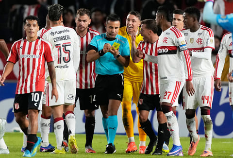 Players of Argentina's Estudiantes de La Plata and Brazil's Flamengo argue with referee Piero Maza during a Copa Libertadores Group A soccer match in La Plata, Argentina.
