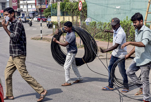 Workers carry a pile of wire on International Labour Day, in Chikkamagaluru, Karnataka.