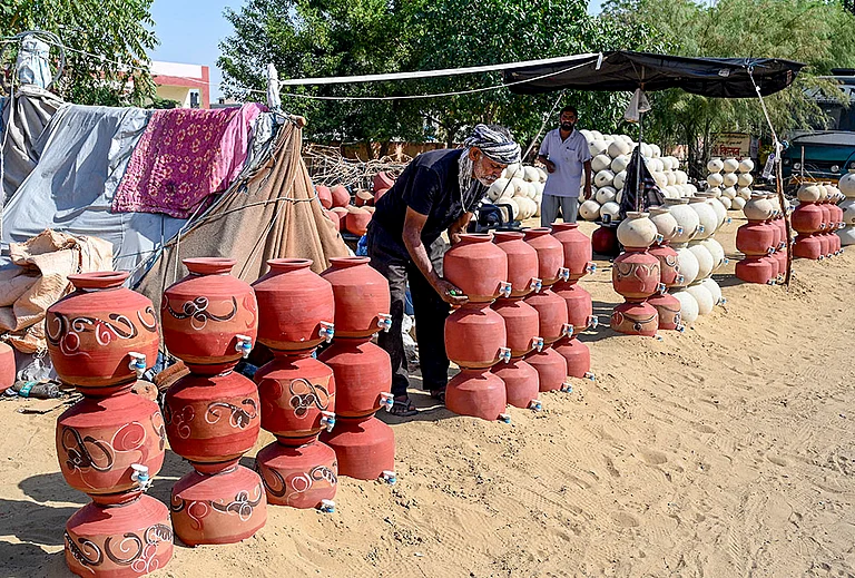 A vendor arranges clay pots for sale on a hot summer day, in Bikaner, Rajasthan. - | Photo: PTI