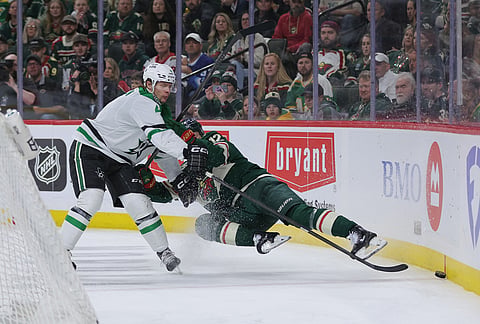 Dallas Stars defenseman Miro Heiskanen, left, and Minnesota Wild left wing Matt Boldy (12) battle for the puck during the third period of Game 6 in the first round of the NHL hockey Stanley Cup playoff series in St. Paul, Minnesota.