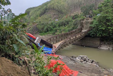A view of the collapsed Bailey bridge over the Tuivai river after two trucks loaded with cement were crossing it on late Thursday, in Churachandpur district, Manipur. 