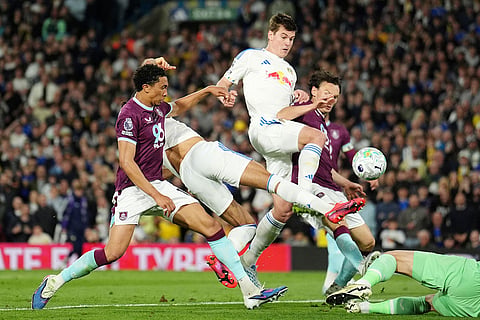 Leeds United's Dominic Calvert-Lewin, second from left, scores their third goal during the English Premier League soccer match between Leeds United and Burnley in Leeds, England.