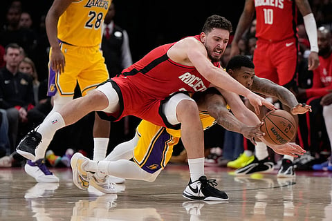 Houston Rockets center Alperen Sengun, left, and Los Angeles Lakers guard Marcus Smart (36) dive for a loose ball during the first half of Game 6 of a first-round NBA playoffs basketball series in Houston.