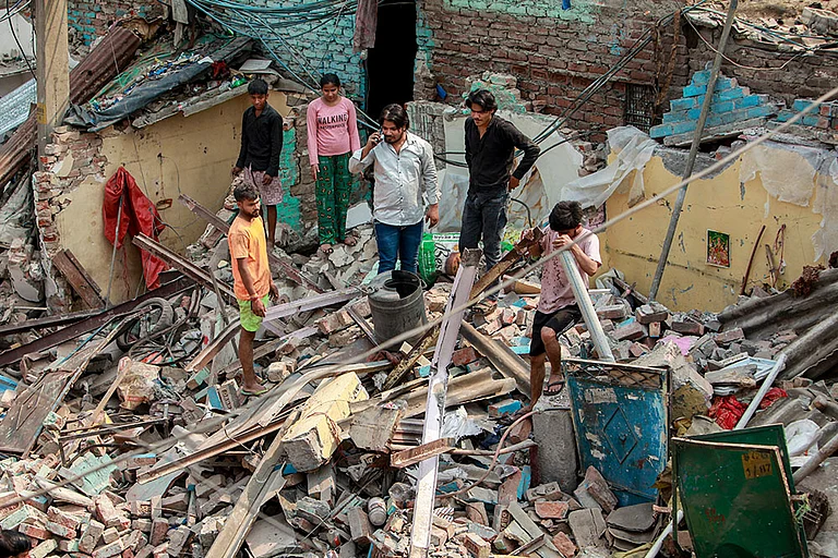 New Delhi: People gather at a demolished structure after an anti encroachment drive was carried out by Municipal Corporation of Delhi (MCD) at Wazirpur industrial area, in New Delhi. - | PTI Photo