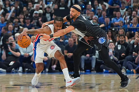 Orlando Magic guard Jalen Suggs, right, tries to steal the ball from Detroit Pistons guard Daniss Jenkins, left, during the second half in Game 6 of a first-round NBA basketball playoffs series in Orlando, Fla.