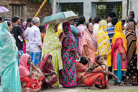 Voters wait in queues to cast their votes at a polling station during a repoll ordered by the Election Commission following reports of electoral malpractices, at Magrahat Paschim constituency, in South 24 Parganas district, West Bengal.