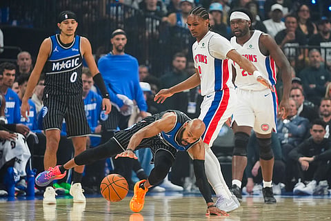 Orlando Magic guard Jevon Carter, front left, dives for the ball in front of Detroit Pistons guard Ausar Thompson, front right, during the first half in Game 6 of a first-round NBA basketball playoffs series in Orlando, Fla.
