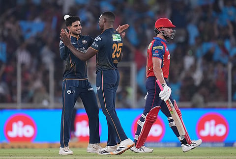Gujarat Titans' Kagiso Rabada, center, celebrates the wicket of Punjab Kings' Suryansh Shedge with Gujarat Titans' captain Shubman Gill during the Indian Premier League cricket match between Gujarat Titans and Punjab Kings in Ahmedabad.