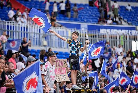 Lyonnes fans celebrate at the the end of the Women's Champions League semifinal, second leg, soccer match between OL Lyonnes and Arsenal, in Decines, outside Lyon, France.