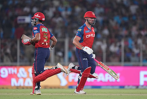 Punjab Kings' Marcus Stoinis, right, and Suryansh Shedge run between the wickets during the Indian Premier League cricket match between Gujarat Titans and Punjab Kings in Ahmedabad.
