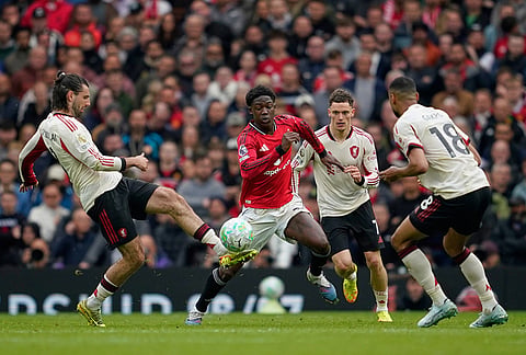 Liverpool's Dominik Szoboszlai, left, challenges for the ball with Manchester United's Kobbie Mainoo during the English Premier League soccer match between Manchester United and Liverpool in Manchester, England.