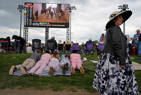Fans watch a video board before the 152nd running of the Kentucky Derby horse race at Churchill Downs, in Louisville, Kentucky.