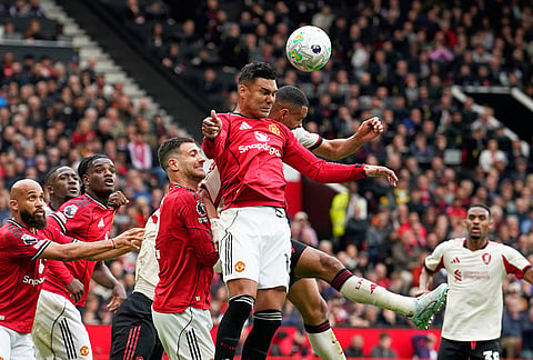 Manchester United's Casemiro, centre, heads the ball during the English Premier League soccer match between Manchester United and Liverpool in Manchester, England.