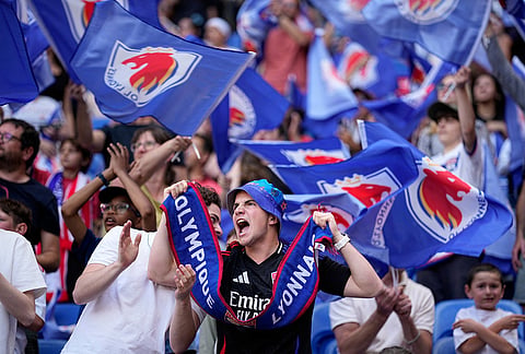 Lyonnes fans cheer during the Women's Champions League semifinal, second leg, soccer match between OL Lyonnes and Arsenal, in Decines, outside Lyon, France.